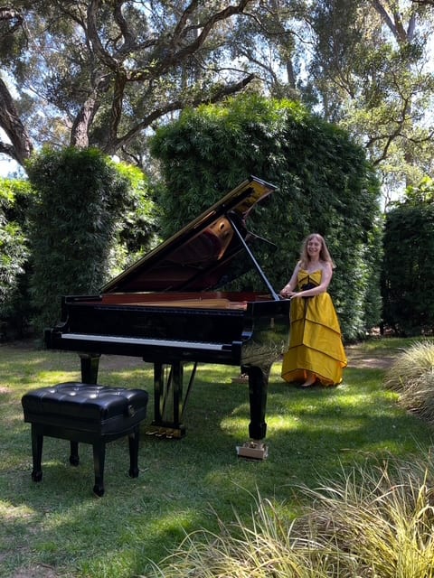 Katya Grineva in a yellow gown beside a grand piano set on the lawn of a garden in California
